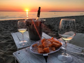Ice cream on table by sea during sunset