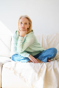 Portrait of woman sitting on sofa at home