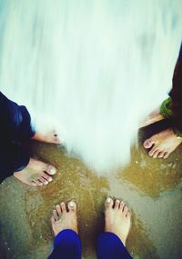 Low section of person standing in water