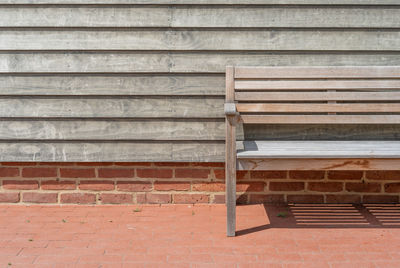 Empty bench against wall