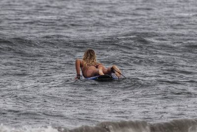 Rear view of shirtless man in sea