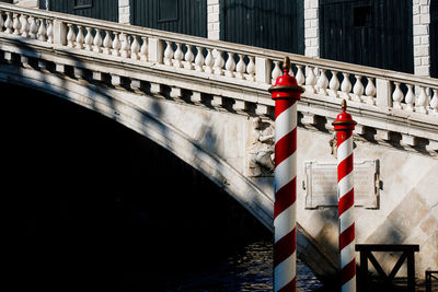 Striped metallic poles against bridge