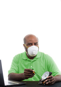 Portrait of man holding camera over white background