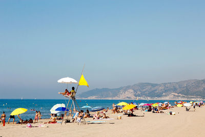 People on beach against sky