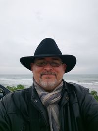 Portrait of man standing at beach against sky