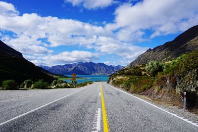 Surface level of road by mountains against sky