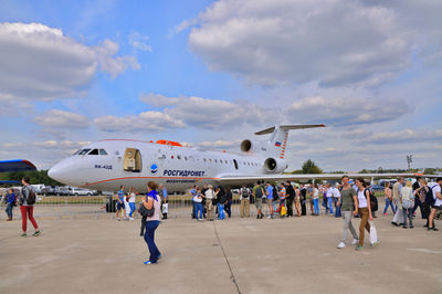 People at airport against sky