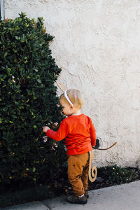 Rear view of boy standing by plants