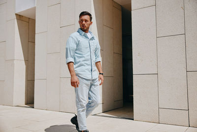 Full length of man standing against wall