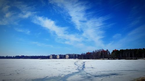 Scenic view of snow covered land against blue sky