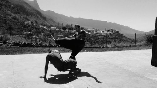 Men fighting on footpath against mountains