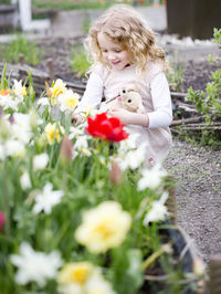 Smiling girl looking at flowers