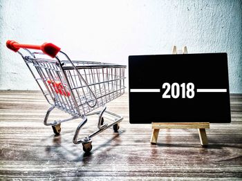 Shopping cart by blackboard with 2018 sign text on table