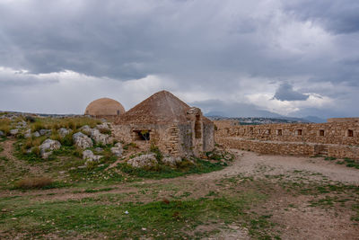 Old ruins on field against sky