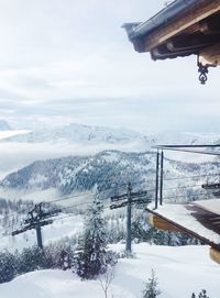 Snow covered landscape and mountains against sky