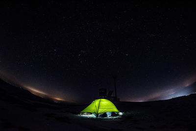 Rear view of person on field against sky at night