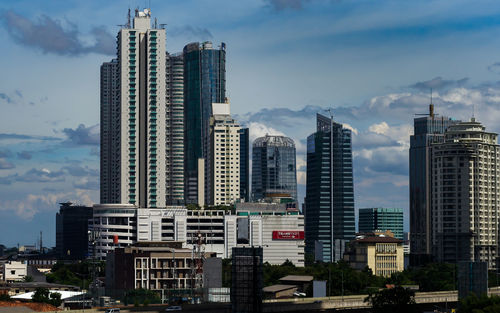 View of skyscrapers against cloudy sky