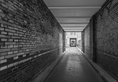 Empty narrow corridor along buildings