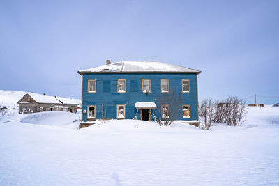 Built structure on snow covered land against sky