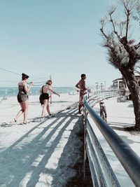 People walking on road against clear sky