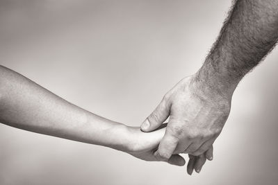 Close-up of man holding hands over gray background