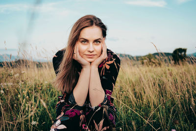 Portrait of woman sitting on field