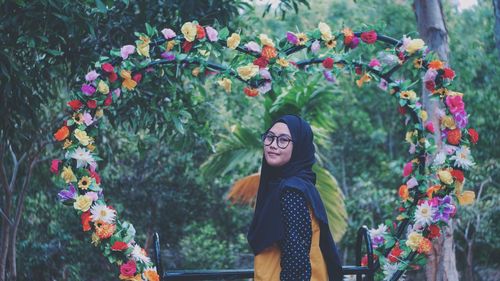 Woman standing by flowering plants