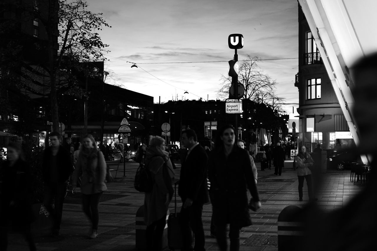 city, architecture, building exterior, built structure, street, large group of people, walking, real people, men, city life, street light, outdoors, women, sky, day, adult, people