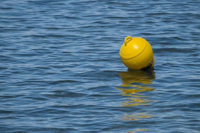 Close-up of yellow buoy floating on water