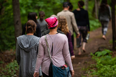 Rear view of people walking in forest
