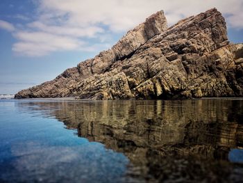 Scenic view of rocks in sea against sky