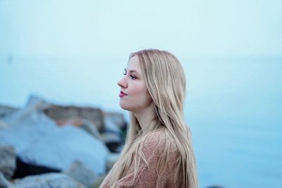 Portrait of a beautiful young woman against sky