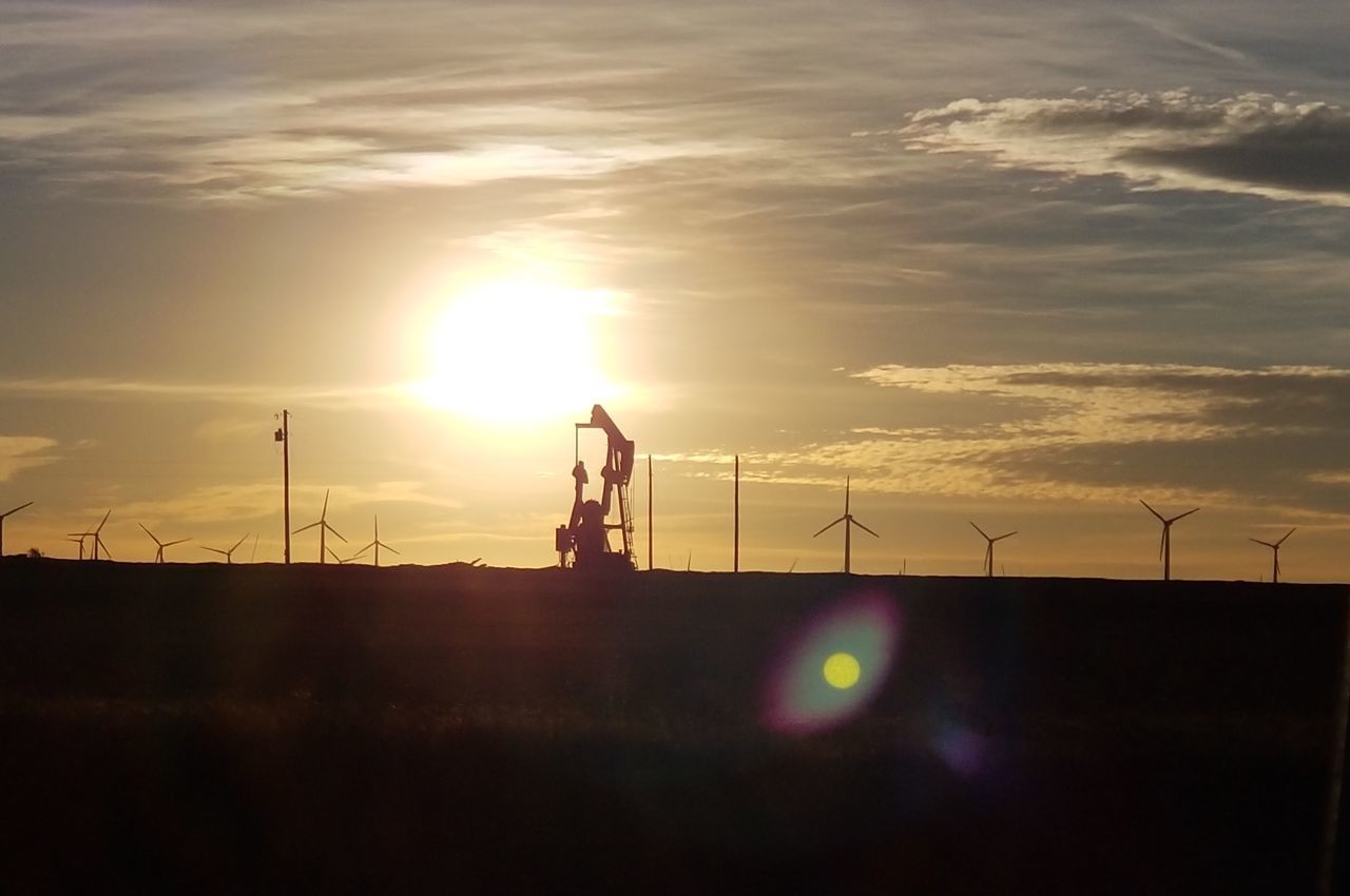 SILHOUETTE OF WIND TURBINES ON LAND AGAINST SKY