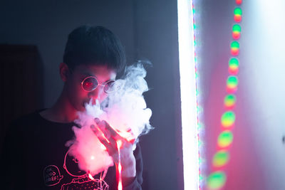 Portrait of boy holding multi colored lights