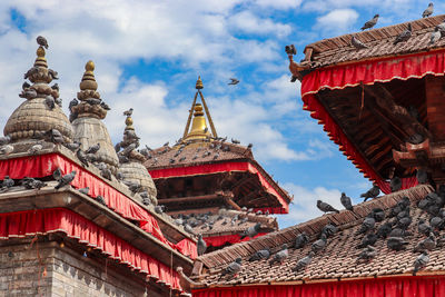 Low angle view of temple building against cloudy sky