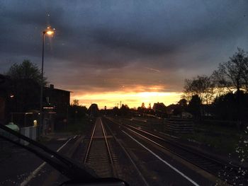 Railroad tracks against cloudy sky