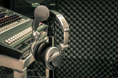 Close-up of headphones hanging on microphone stand at recording studio