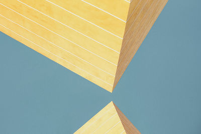 Low angle view of yellow building against clear blue sky