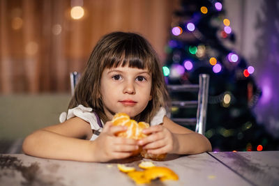 Portrait of girl sitting on table