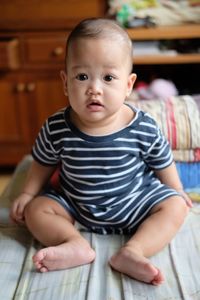 Portrait of cute baby girl sitting at home