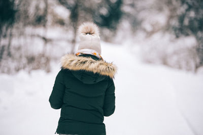 Rear view of woman on snow covered field