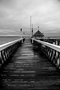 Wooden footbridge on pier over sea against sky - yarmouth pier