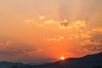 Scenic view of silhouette mountains against romantic sky at sunset