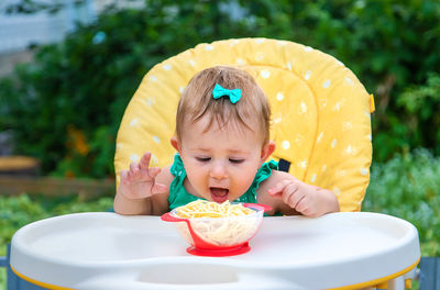 Cute girl eating spaghetti outdoors