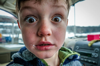 Close-up portrait of shocked boy in car