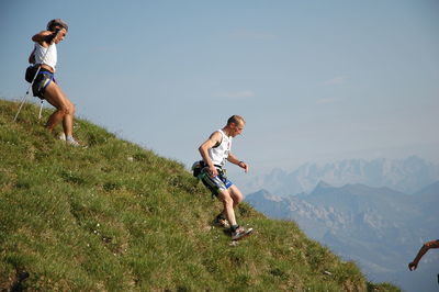 Full length of friends on mountain against sky