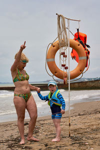 Rear view of woman standing at beach