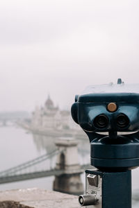 Close-up of binoculars against sky