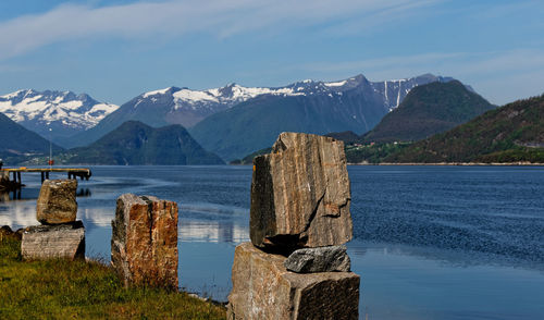 Scenic view of lake by snowcapped mountains against sky