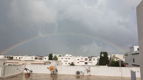 Scenic view of rainbow over buildings in city